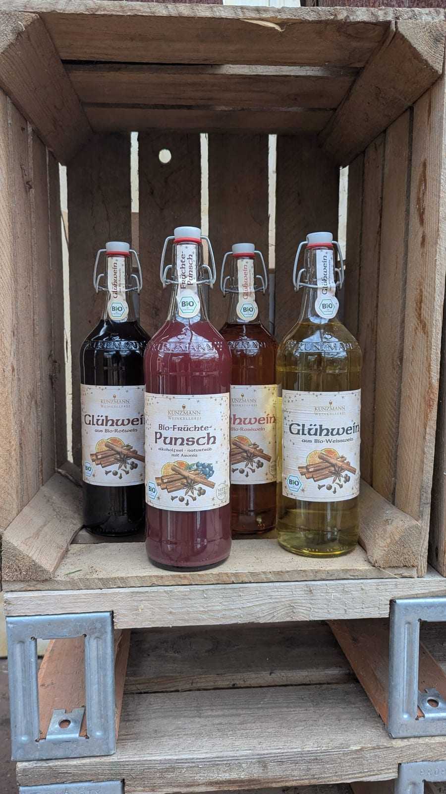 Flaschen Glühwein und Früchtepunsch in einer Holzkiste im Verkaufsraum