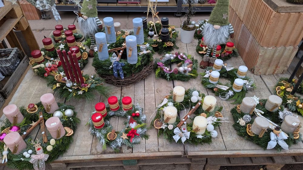 Draufsicht auf das Adventssortiment mit Gestecken, Kerzen und Zapfen